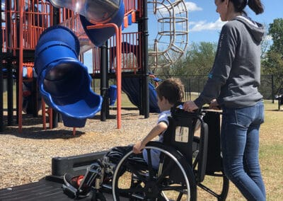 Person on wheelchair entering playground using access ramp